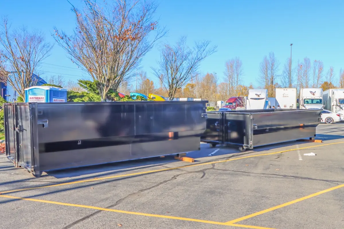 Professional dumpster rental service with roll-off container on residential driveway in Pequannock